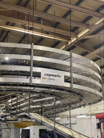 Multi level stainless steel Capmatic spiral cooling conveyor inside a food production plant